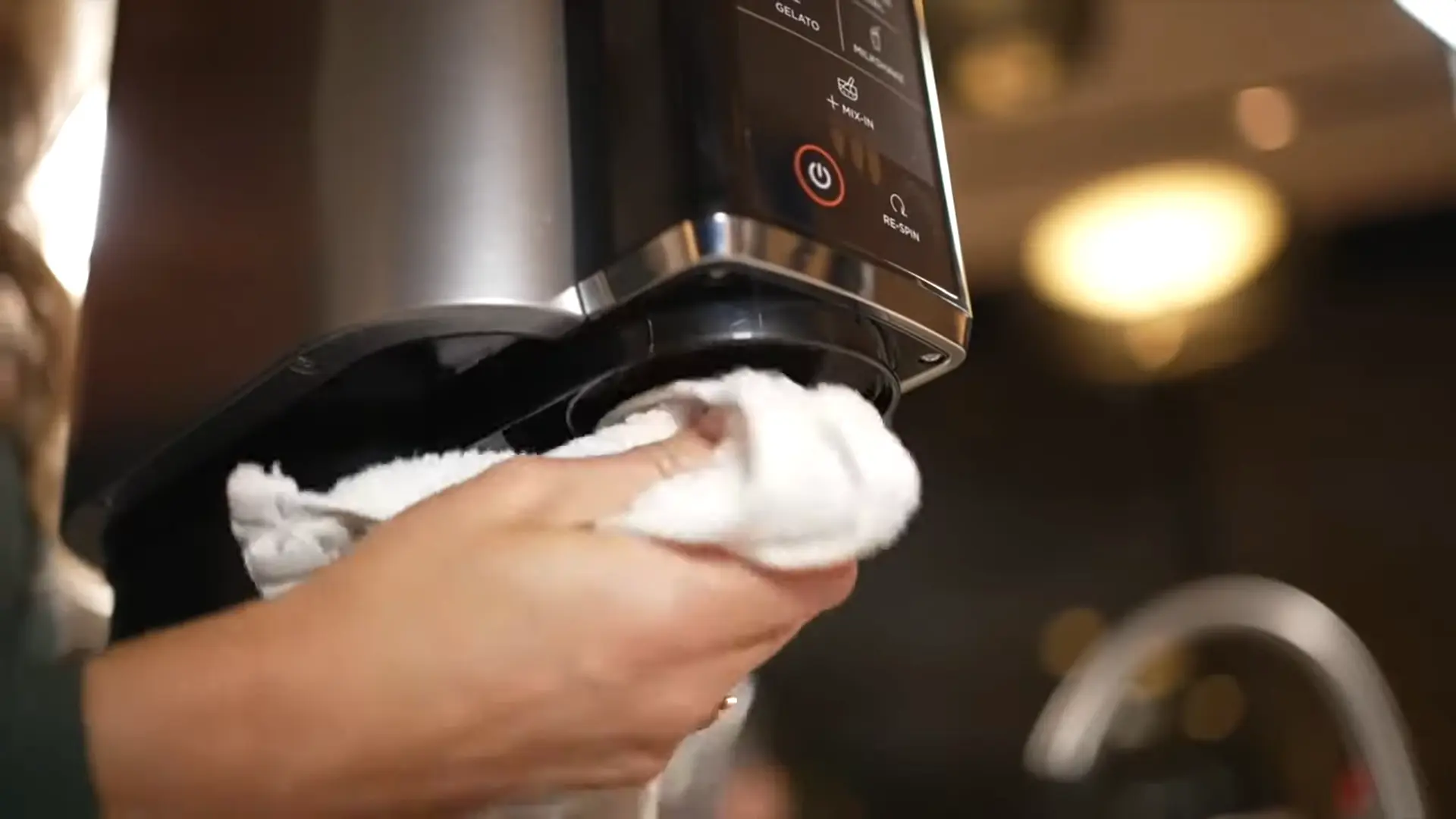 All Ninja CREAMi parts disassembled and laid out before cleaning including paddle, pint, lid, gasket, and motor base